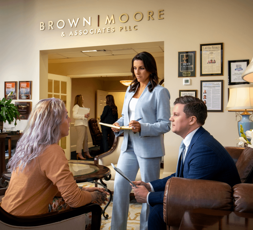 Brown Moore & Associates attorneys with client