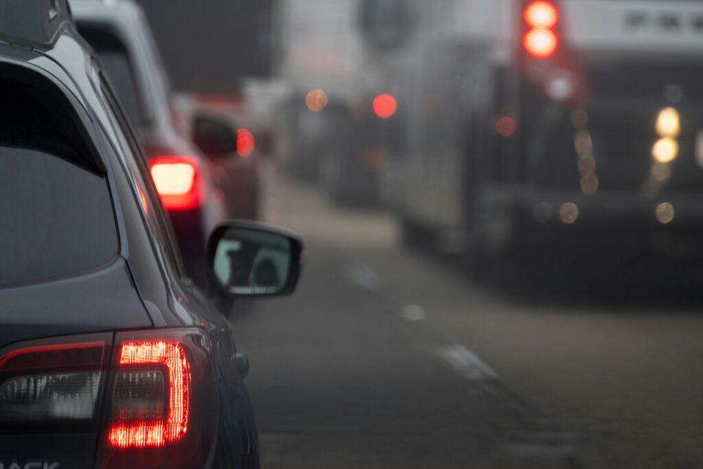 Cars navigating a busy road with traffic lights, showcasing urban traffic flow and congestion.